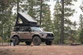 GX 550 camp set up with off road bumpers, roof rack, tent, light brackets, and molle panels.