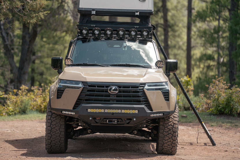 GX 550 fully equipped on camping trip with off road bumpers, roof rack, tent, light brackets, and molle panels.
