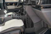 Passenger footwell view of the Center Console Molle Panels for the 2022-2026 INEOS Grenadier & Quartermaster
