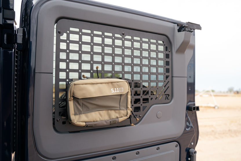 A beige tactical pouch with the brand name '5.11' printed in white on the front, hanging from a 2022-2026 INEOS Grenadier Passenger Rear Door Window Molle Panel 
